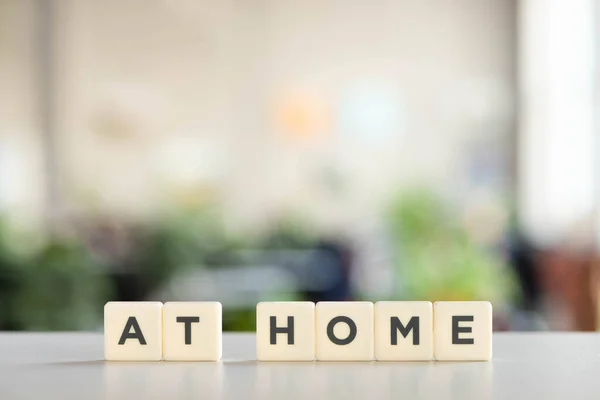 White cubes with at home lettering on white desk in office — Stock Photo