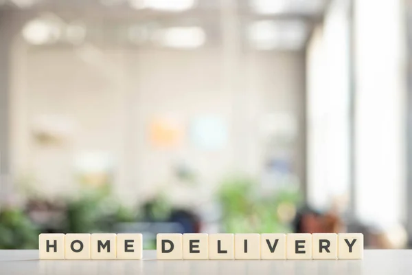 White blocks with home delivery lettering on white surface — Stock Photo