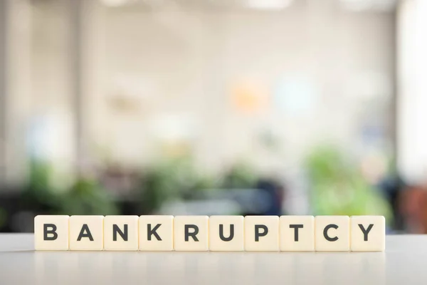 Белые блоки с надписью о банкротстве на офисном столе — стоковое фото