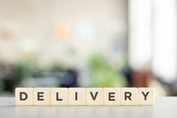 White blocks with delivery lettering on white surface — Stock Photo