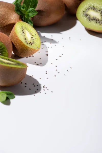 Selective focus of kiwi fruits near black seeds on white — Stock Photo