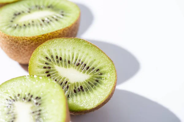 Foyer sélectif des moitiés de kiwis verts sur blanc — Photo de stock