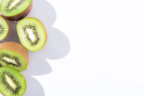 Vista superior de kiwi fresco e verde metades de frutas em branco — Fotografia de Stock