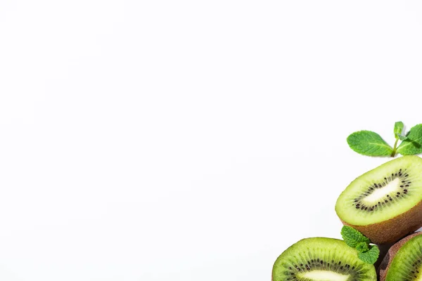 Top view of ripe and green kiwi fruit halves near peppermint isolated on white — Stock Photo