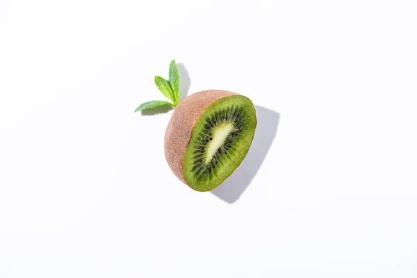 Vista dall'alto di kiwi biologico metà vicino a foglie di menta piperita su bianco — Foto stock