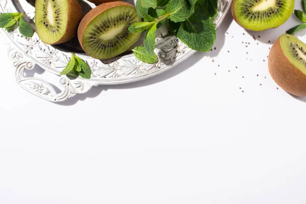 Vista superior de frutas kiwi suculentas perto de hortelã-pimenta na placa de prata no branco — Fotografia de Stock