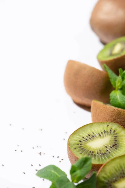 Foyer sélectif de kiwis verts près de menthe poivrée biologique et de graines noires sur blanc — Photo de stock