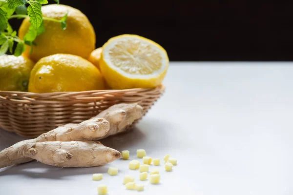 Panier de citrons et racine de gingembre sur fond blanc isolé sur fond noir — Photo de stock