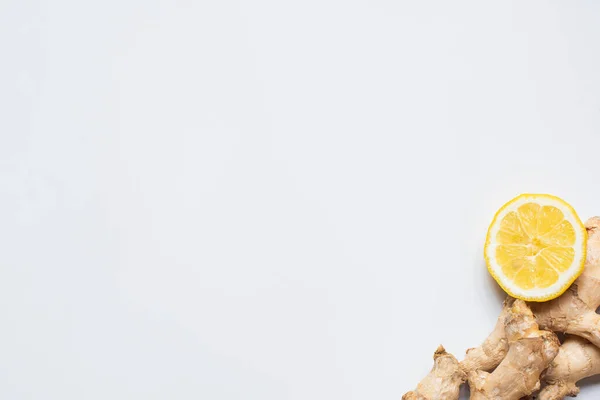 Draufsicht auf frische Zitronen- und Ingwerwurzel auf weißem Hintergrund — Stockfoto