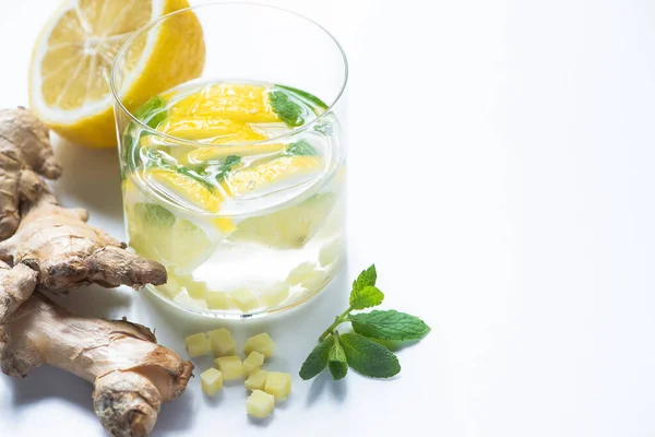 Limonade au gingembre frais en verre avec citron et menthe sur fond blanc — Photo de stock