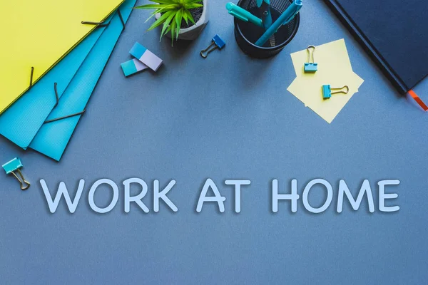 Vista dall'alto della cancelleria e del lavoro a casa lettering sulla superficie blu — Foto stock