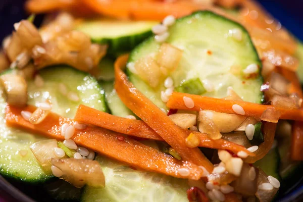 Primer plano de pepinos en escabeche con zanahoria y sésamo - foto de stock