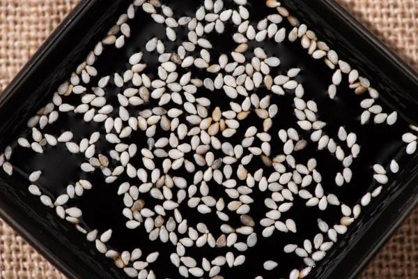 Vue du dessus du sésame blanc en sauce soja salée — Photo de stock