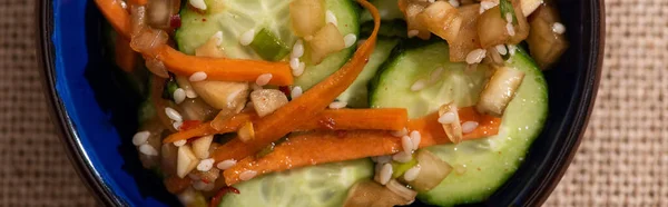 Panoramic crop of pickled cucumbers with carrot and sesame — Stock Photo