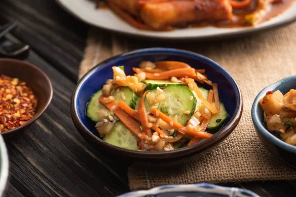 Selective focus of pickled and cut cucumbers with carrot near dried chili pepper — Stock Photo