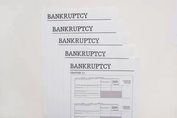 Vista superior de los papeles de bancarrota sobre fondo blanco - foto de stock