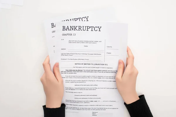 Partial view of woman holding bankruptcy papers on white background — Stock Photo