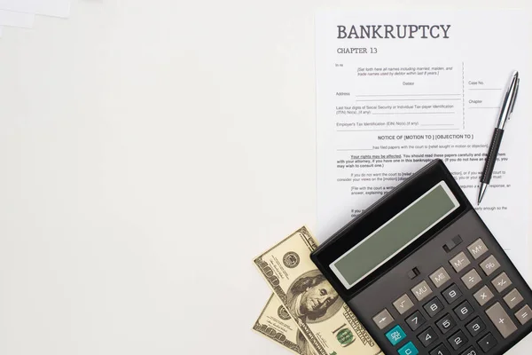 Vista superior del papel de bancarrota con pluma, dinero y calculadora sobre fondo blanco - foto de stock