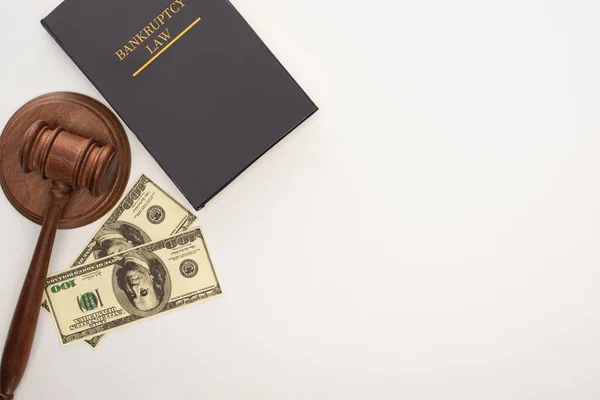 Vista superior del libro de leyes de bancarrota, mazo y dinero sobre fondo blanco - foto de stock