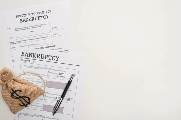 Top view of bankruptcy papers, money bag on white background — Stock Photo