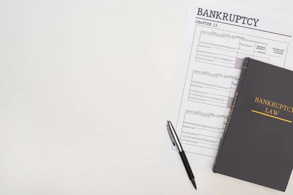 Vista superior do papel da bancarrota, da pena e do livro da lei no fundo branco — Fotografia de Stock