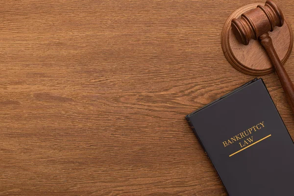 Vue du haut du livre de droit de la faillite et marteau sur fond en bois — Photo de stock