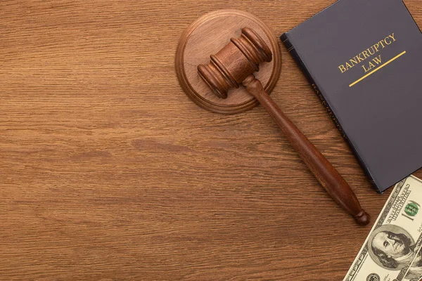 Vista superior del dinero, libro de leyes de bancarrota y martillo sobre fondo de madera — Stock Photo