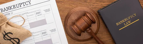 Top view of money bag, bankruptcy paper, law book and gavel on wooden background, panoramic shot — Stock Photo