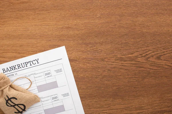 Vista dall'alto del sacchetto di soldi, carta fallimento su sfondo di legno — Foto stock