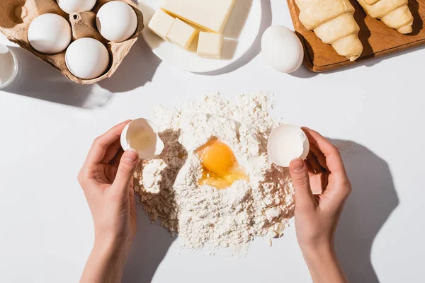 Vista recortada de la mujer haciendo masa para croissants sobre fondo blanco - foto de stock