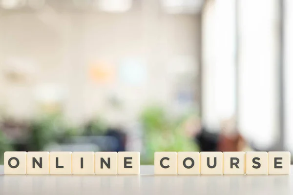 Bloques blancos con letras de curso en línea en escritorio blanco - foto de stock