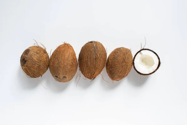 Vue de dessus des noix de coco entières savoureuses fraîches et demi sur fond blanc — Photo de stock