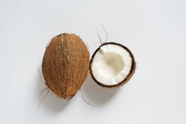 Vue de dessus de noix de coco entière savoureuse fraîche et demi sur fond blanc — Photo de stock