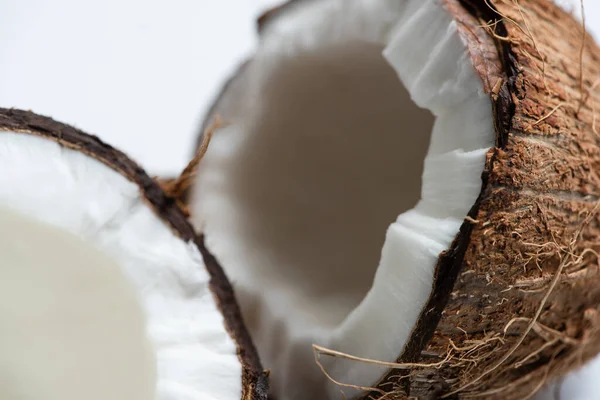 Vista de cerca de sabrosas mitades de coco sobre fondo blanco - foto de stock