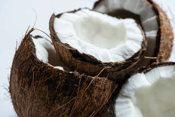 Vista de cerca de sabrosas mitades de coco sobre fondo blanco - foto de stock