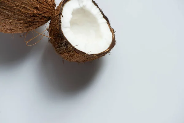 Frische leckere ganze Kokosnuss und die Hälfte auf weißem Hintergrund — Stockfoto