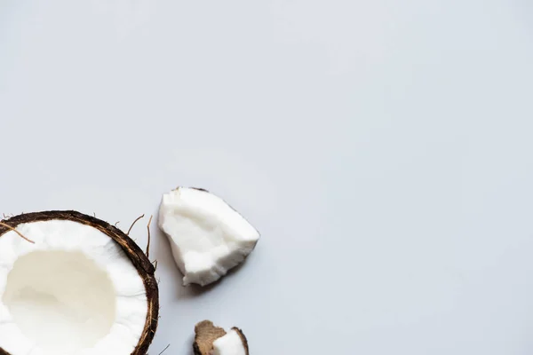 Top view of cracked tasty coconut half and pieces on white background — Stock Photo