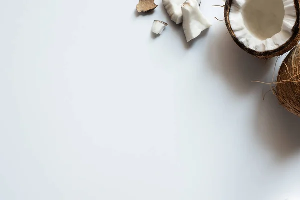 Top view of cracked tasty coconut half and pieces on white background — Stock Photo