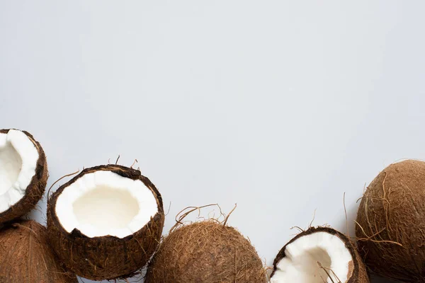 Draufsicht auf frische leckere ganze Kokosnüsse und -hälften auf weißem Hintergrund — Stockfoto