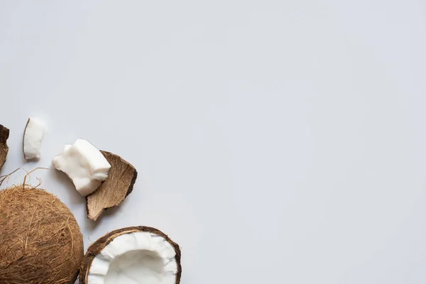 Вид зверху на свіжий смачний цілий і тріснутий кокоси на білому тлі — стокове фото