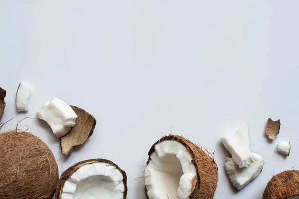 Top view of fresh tasty whole and cracked coconuts on white background — Stock Photo