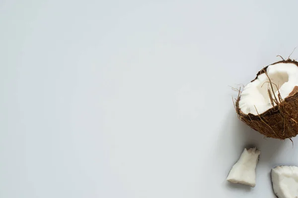 Draufsicht auf frische leckere Kokosnusshälften und rissige Stücke auf weißem Hintergrund — Stockfoto