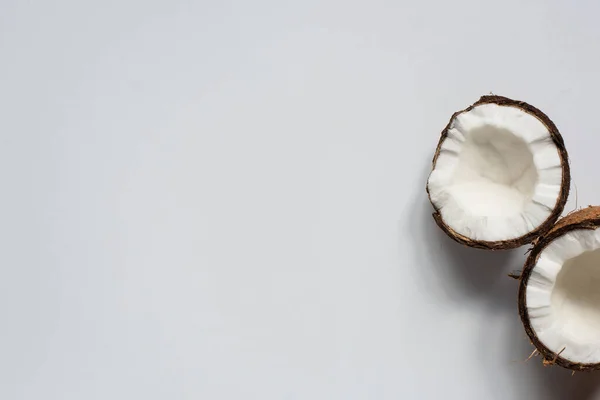 Vue de dessus des moitiés savoureuses fraîches de noix de coco sur fond blanc — Photo de stock