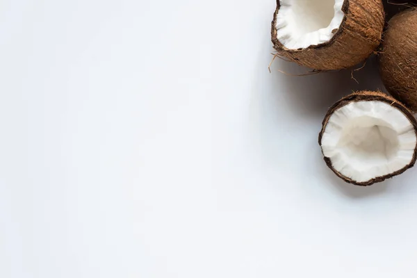 Vue de dessus des moitiés savoureuses fraîches de noix de coco sur fond blanc — Photo de stock