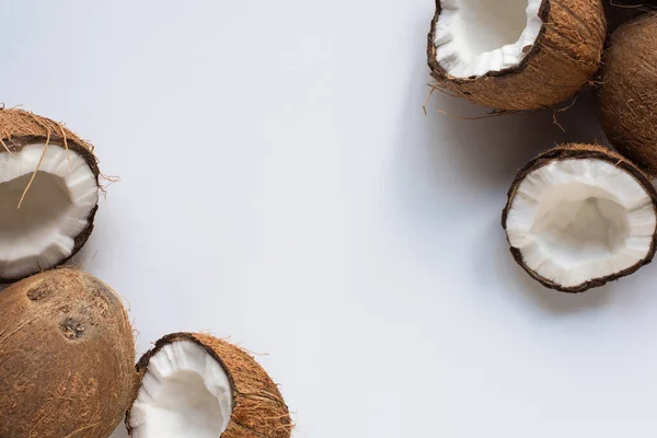 Vue de dessus des noix de coco entières savoureuses fraîches et demi sur fond blanc — Photo de stock