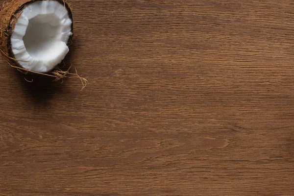 Vista dall'alto di fresco gustoso cocco metà sul tavolo di legno — Foto stock