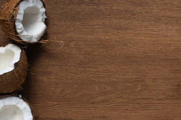 Top view of fresh tasty cracked coconuts on wooden table — Stock Photo