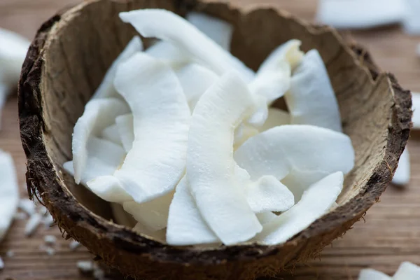 Vista ravvicinata di fiocchi di cocco saporiti freschi in guscio — Foto stock