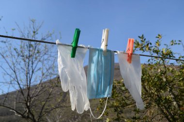 Çamaşır ipinde plastik eldivenler ve yüz maskesi - Corona krizi