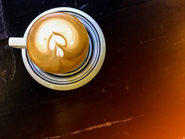 Cappuccino ve su güneş ışığı ile masada